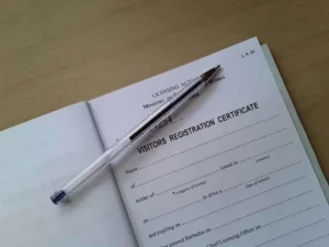 Blank visitor's registration certificate with a pen on top