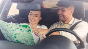 couple inside the car looking at Map
