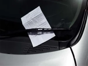 Parking ticket placed under a windshield wiper on a hire car