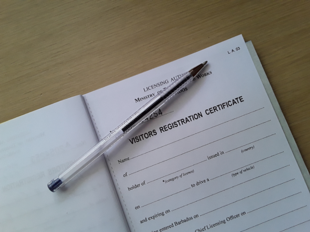 Blank visitor's registration certificate (visitors permit) with pen on top