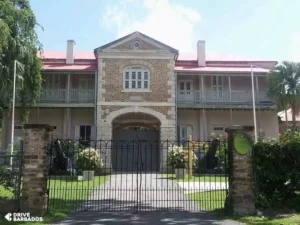 The historic Barbados Museum building at Garrison Savannah with a gated entrance and lush garden