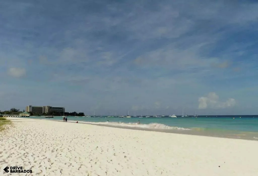 Serene Carlisle Bay Beach with white sands and calm turquoise waters with the Hilton hotel in the background, Barbados